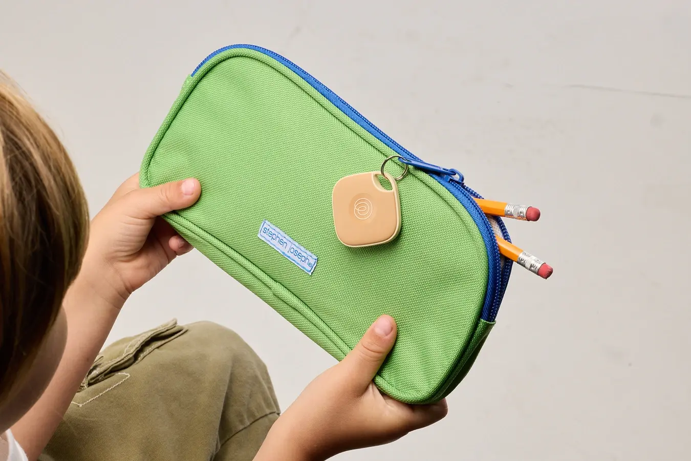 Life360 Tile - Clay on a green pencil pouch