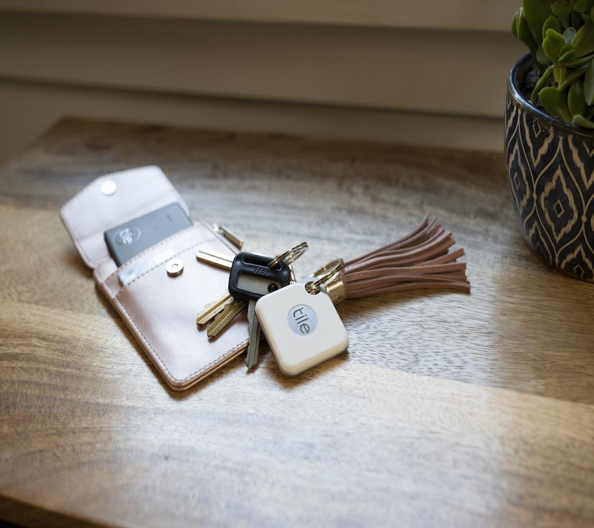 White tile mate attached to car keys on top of a wallet