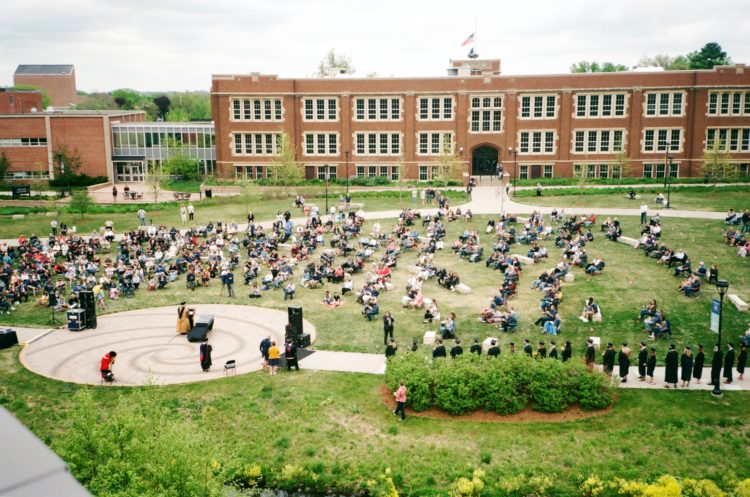 College campus quad with students hanging out on a lawn